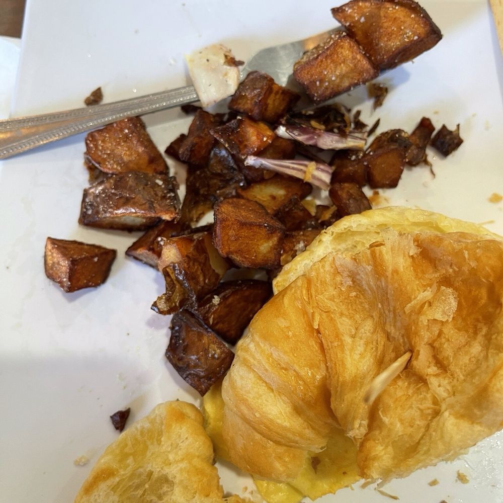 Croissant and sausage sandwich with potatoes. Croissant and sausage sandwich with potatoes.