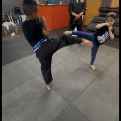 Little phoenix class working on technique closely watched by Grand Master Luther