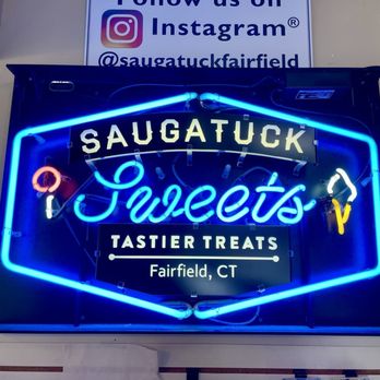 Saugatuck Sweets - Saugatuck Sweets! - Colorful neon sign for Saugatuck Sweets in Fairfield, CT, featuring the shop's name, treats, and social media handle. - Ice Cream & Frozen Yogurt Near Me - Fairfield, Connecticut