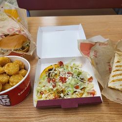 Taco John's - Quite the spread - Taco Beef Burger, Potato Oles,  Beefy Tostada, Chicken Quesadilla.