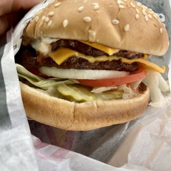 Carl's Jr - a hand holding a cheeseburger - Fast Food Near Me - Ely, Nevada