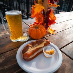 WonderLove - Signature Oktoberfest Bratwurst features a juicy, perfectly seared sausage cradled in a soft pretzel bun and slathered with zesty mustard.