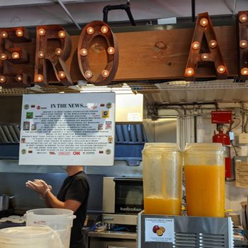 Quiero Arepas - Arepas on the grill in the back. Passion fruit juice on the front counter. - Gluten-Free Near Me - Denver, Colorado Quiero Arepas - Arepas on the grill in the back. Passion fruit juice on the front counter. - Gluten-Free Near Me - Denver, Colorado