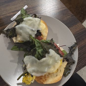 Rogue Coffee - Bagel with scrambled eggs, greens, and cheese on top - Coffee & Tea Near Me - Lakeland, Florida