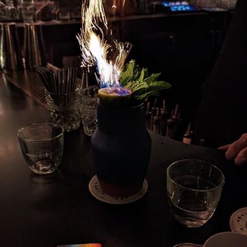 Banzarbar - a person lighting a candle on a table - Cocktail Bars Near Me - New York, New York Banzarbar - a person lighting a candle on a table - Cocktail Bars Near Me - New York, New York
