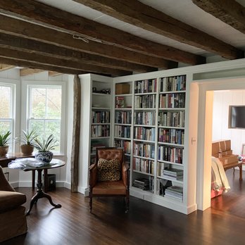 JMS Contracting - a living room with bookshelves and chairs - General Contractors Near Me