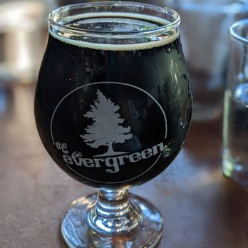 The Evergreen - a glass of beer on a table - American Near Me - Syracuse, New York The Evergreen - a glass of beer on a table - American Near Me - Syracuse, New York