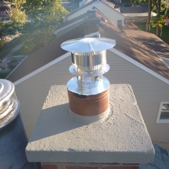 Defender Chimney and Fireplace Services - New chimney topper on the utility chimney with new topper on fireplace chimney on left side - Chimney Sweeps Near Me