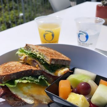 The Wave Kitchen & Bar - The Breakfast Sandwich from Wave: Apple Wood Smoked Bacon, avocado, egg (over-easy), tomato, and romaine on 3-grain toast - Bars Near Me - Vero Beach, Florida The Wave Kitchen & Bar - The Breakfast Sandwich from Wave: Apple Wood Smoked Bacon, avocado, egg (over-easy), tomato, and romaine on 3-grain toast - Bars Near Me - Vero Beach, Florida