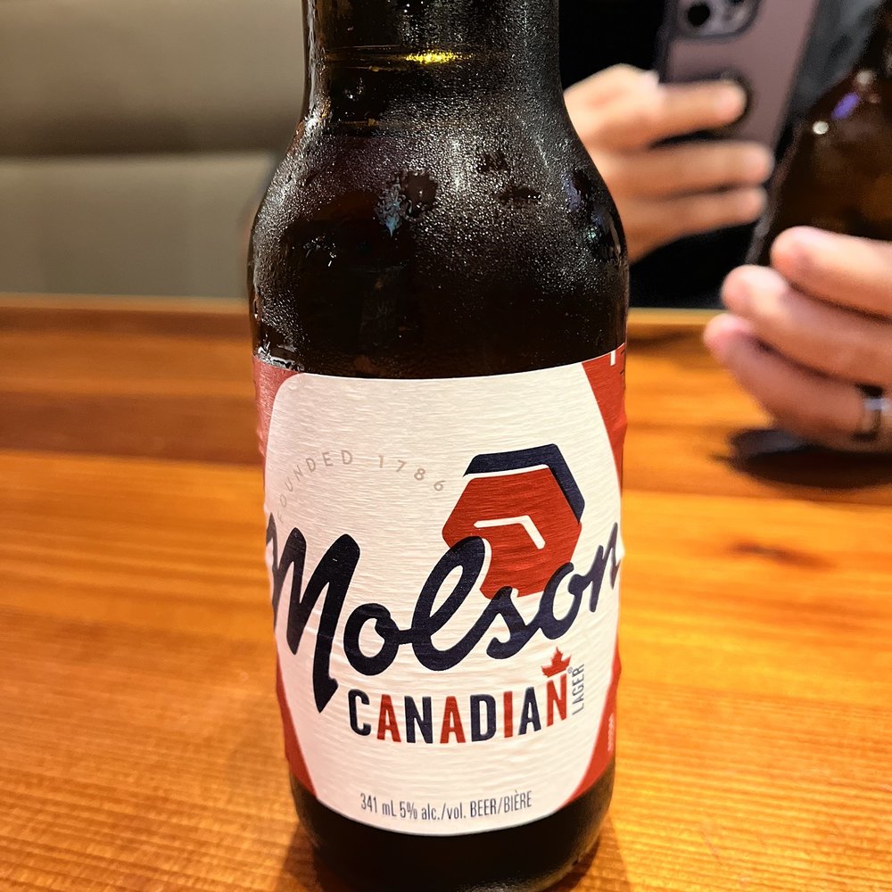a man taking a picture of a bottle of beer a man taking a picture of a bottle of beer
