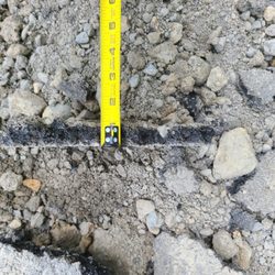 Premier Paving and Sealcoat - Depth of compacted pour... less than an inch in the rubble of one of the original failures.