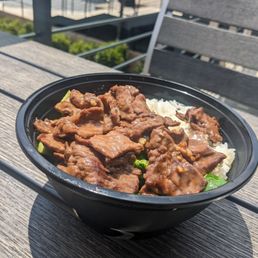 Steak bowl with white rice and vegetables.