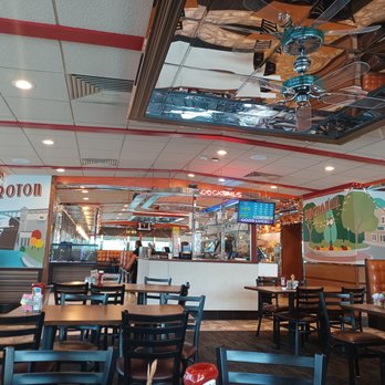 Westchester Diner - the interior of a restaurant - A dining area with tables and chairs, booths along the wall, and a bar in the background, featuring colorful wall murals. - Diners Near Me - Peekskill, New York