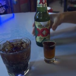 Hideaway Bar - Sitting area / partial blue juke box My drinks are shot of Hennessy / side of Coca Cola His drink is a XX beer
