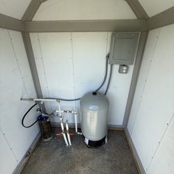 Huston's Water Solutions - Complete water well pump system in a premium insulated well house with dedicated electrical panel.