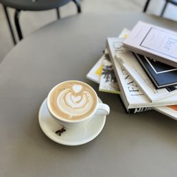 a cup of cappuccino and a stack of magazines