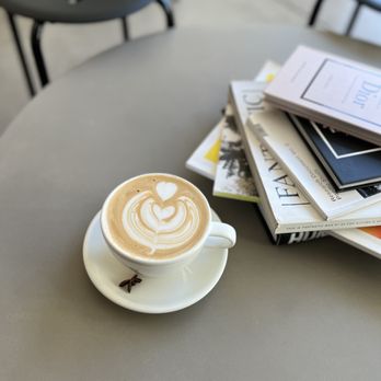 Adapt Cafe - a cup of cappuccino and a stack of magazines - Coffee & Tea Near Me - Portland, Oregon