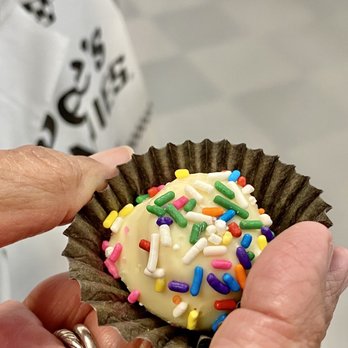 See's Candies - a person holding a cupcake with sprinkles - Candy Stores Near Me - Downey, California