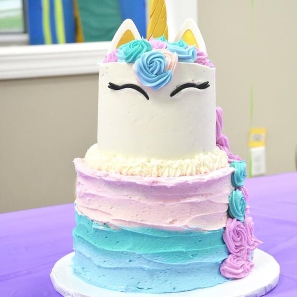 a cake with a unicorn face on top a cake with a unicorn face on top