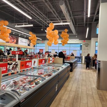Wild Fork - Inside Wild Fork in Oak Park, IL, the store features frozen food sections, orange balloons hanging from the ceiling, and customers shopping. - Seafood Markets Near Me - Oak Park, Illinois