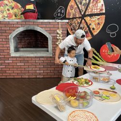 Habitot Children's Museum - Father and son making "pizza" together