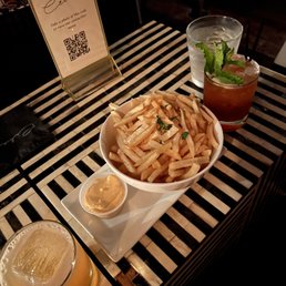 a bowl of french fries and a glass of beer a bowl of french fries and a glass of beer