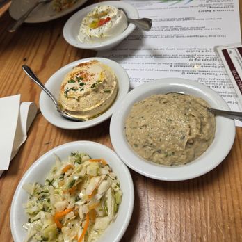 Oren's Hummus - Complimentary salad, next to Oren's eggplant, hummus, and yogurt. - Mediterranean Near Me - Palo Alto, California