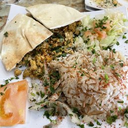 Chicken Shawarma - A plate featuring rice, a small salad with lettuce and tomato, and pita bread, served with herbs and spices.