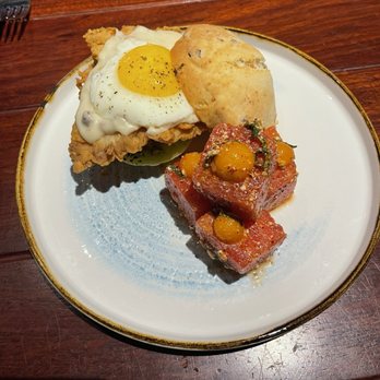 The Ranch - Test items: fried chicken on a jalapeño cheddar biscuit with egg, fried green tomato, and gravy with a side of seasoned watermelon - Steakhouses Near Me - Irving, Texas The Ranch - Test items: fried chicken on a jalapeño cheddar biscuit with egg, fried green tomato, and gravy with a side of seasoned watermelon - Steakhouses Near Me - Irving, Texas