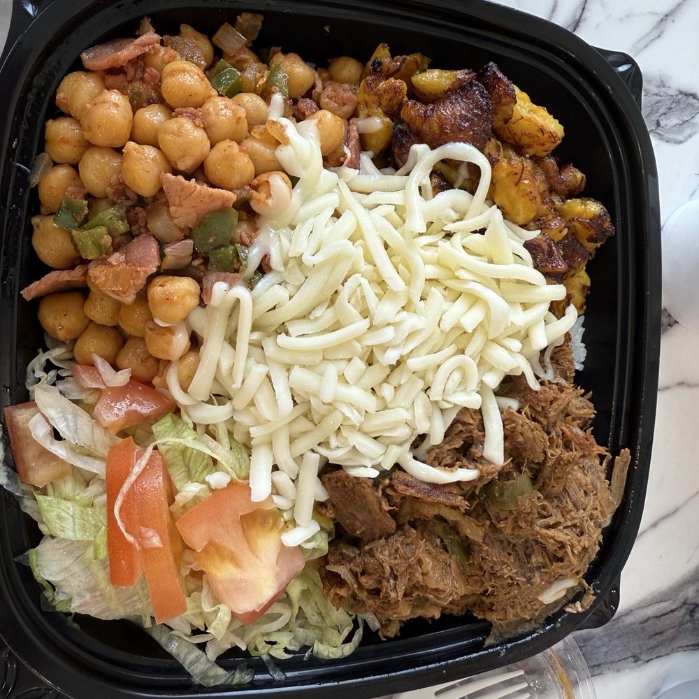 Bowl with ropa vieja, garbanzos, salad, and plantains over rice.