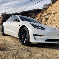 Photo of Sticker City - Sherman Oaks, CA, US. Tesla Model 3 with XPEL Ultimate paint protection, Chrome delete, powder coated wheels and red painted calipers.