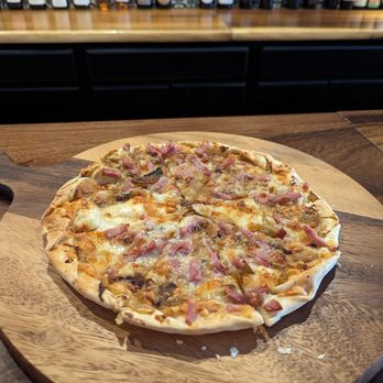 Crave Wine - a pizza on a wooden cutting board - Wine Bars Near Me - Hollister, California