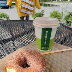 Fresh‑baked donut, hot organic coffee, and our friendly scarecrow watching the road - morning starts here.