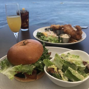 Schooners Monterey - Plaza Burger w/ bacon & a side of Caesar Salad and other plate is Fish & Chips - Seafood Near Me - Monterey, California Schooners Monterey - Plaza Burger w/ bacon & a side of Caesar Salad and other plate is Fish & Chips - Seafood Near Me - Monterey, California