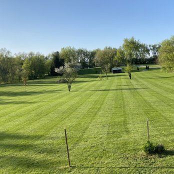 White Pine Landscaping - a large green lawn with trees in the background - Landscaping Near Me
