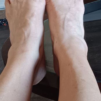 Tina's Nails - Beautiful job as always ! - Feet with blue toenail polish and rings on toes are resting on a surface, with a background of a plant and a door. - Nail Salons Near Me - Modesto, California
