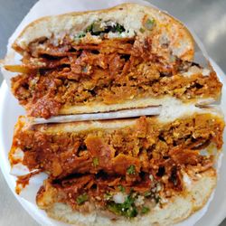 Miss Chilaquiles - Red chilaquiles torta, it comes with breaded chicken breast, onion sour cream, cilantro!