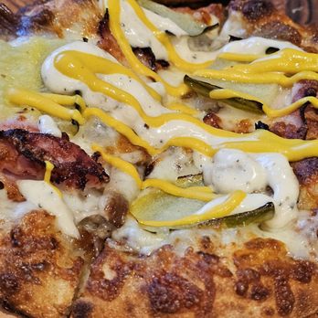 Bobby's Hot And Cheesy - Close-up of the Cuban Pizza, with ham, pork, cheese, pickles, and of course mustard. - Pizza Near Me - Roanoke, Virginia