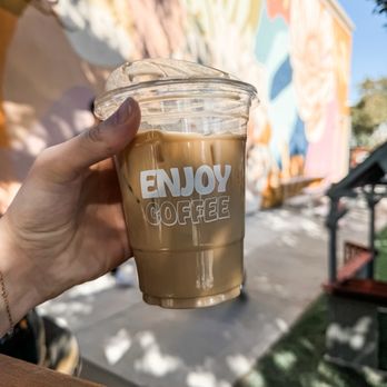 Enjoy Coffee - Iced Vanilla Latte in front of the beautiful wall mural on their building - Coffee & Tea Near Me - Vacaville, California