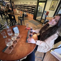a woman sitting at a table with wine glasses a woman sitting at a table with wine glasses