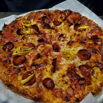 Venus II - Limguica and hot pepper pizza.  1/2 price on Mondays - A freshly baked pizza featuring slices of sausage, yellow peppers, and melted cheese, placed on a white paper liner. The pizza has a golden-brown crust and appears to be served in a casual dining setting, possibly at a coastal restaurant or sports bar known for seafood and pizza offerings. - Sports Bars Near Me - Marshfield, Massachusetts