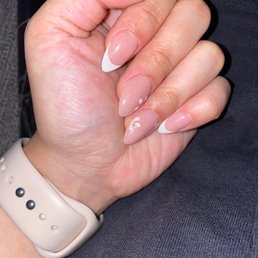 Almond shape acrylic, with a natural pink dip powder. Design on the middle and ring finger and French tips on all others!