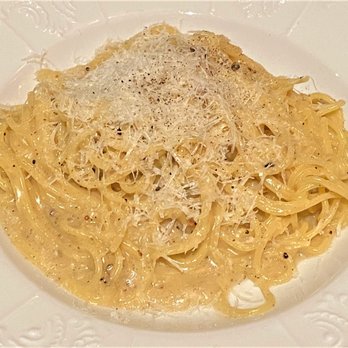 Geppetto - A white ceramic plate holds a serving of fettuccine pasta coated in a creamy sauce, topped with grated cheese and a sprinkle of black pepper. The dish appears to be an Italian-inspired pasta, possibly Alfredo or similar, presented simply on a plain white plate. - Italian Near Me - Cambridge, Massachusetts