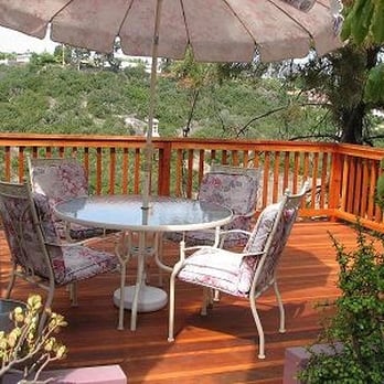 Veria Construction - a deck with a table and chairs and an umbrella - General Contractors Near Me Veria Construction - a deck with a table and chairs and an umbrella - General Contractors Near Me