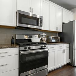 Rockyridge Handyman - Modern kitchen with white cabinets, stainless steel appliances, and updated finishes.