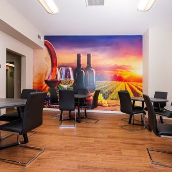 55+ FountainGlen Temecula - a room with tables and chairs and a mural of wine bottles and glasses on the wall - Apartments Near Me - Temecula, California 55+ FountainGlen Temecula - a room with tables and chairs and a mural of wine bottles and glasses on the wall - Apartments Near Me - Temecula, California