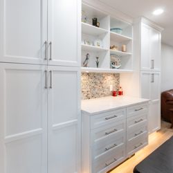 OZ General Contracting - White & wood 2-tone kitchen  L-shaped island, quartz everywhere, custom dining unit + sleek undercab & toe-kick lighting. #DreamKitchen