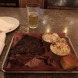 Two meat platter with two sides and cornbread.