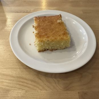 Yemen Grill - Basbousa. This is a cake made with semolina and coconut soaked in a sugar-based syrup - Arabic Near Me - Aurora, Colorado Yemen Grill - Basbousa. This is a cake made with semolina and coconut soaked in a sugar-based syrup - Arabic Near Me - Aurora, Colorado