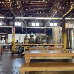Inside a brewery with tables and benches Inside a brewery with tables and benches